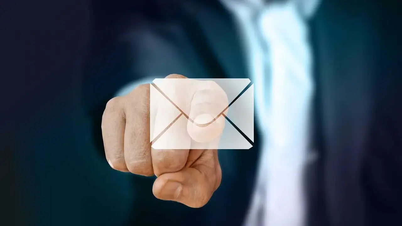 Pekande finger med ett e-post-ikon över. Dags att byta mailadress för en ny start.