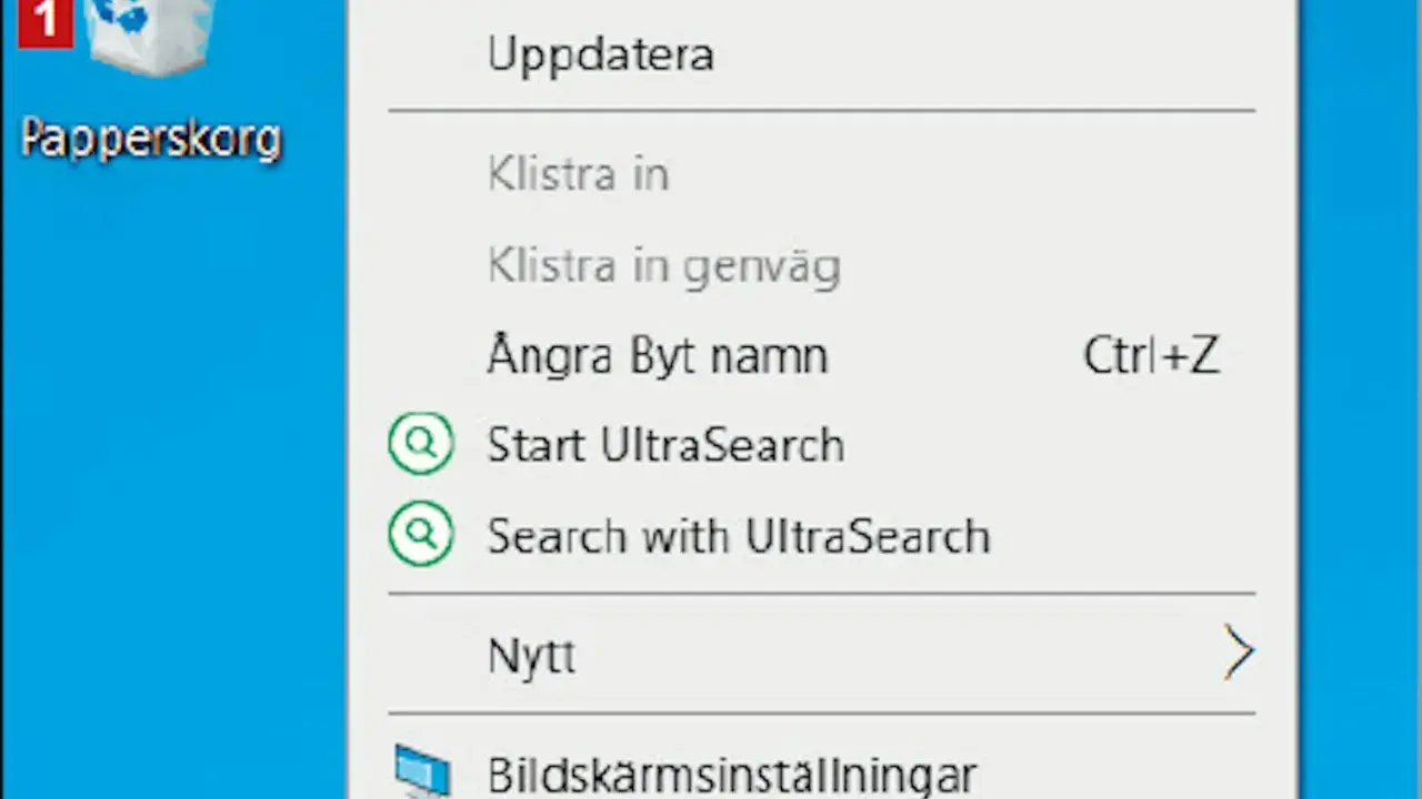 Här är en skärmdump av en dator där man kan se en ikon för "Papperskorg" och en meny. Var hittar jag papperskorgen? Den är markerad med siffran 1.