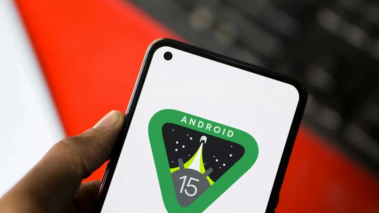 En hand håller en telefon med Android 15-logotypen, en raket som skjuter upp mot stjärnorna.
