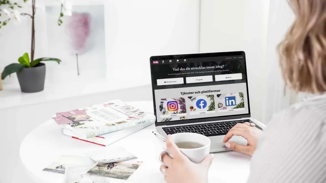 En person använder ett **publiceringsverktyg för sociala medier** på en laptop. På skärmen syns ikoner för Instagram, Facebook och LinkedIn.