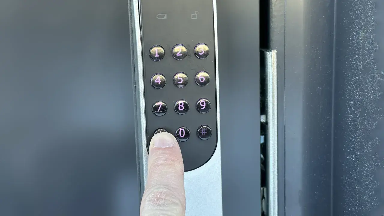 En finger trycker på nollan på en Yale Doorman V2N med wifi.