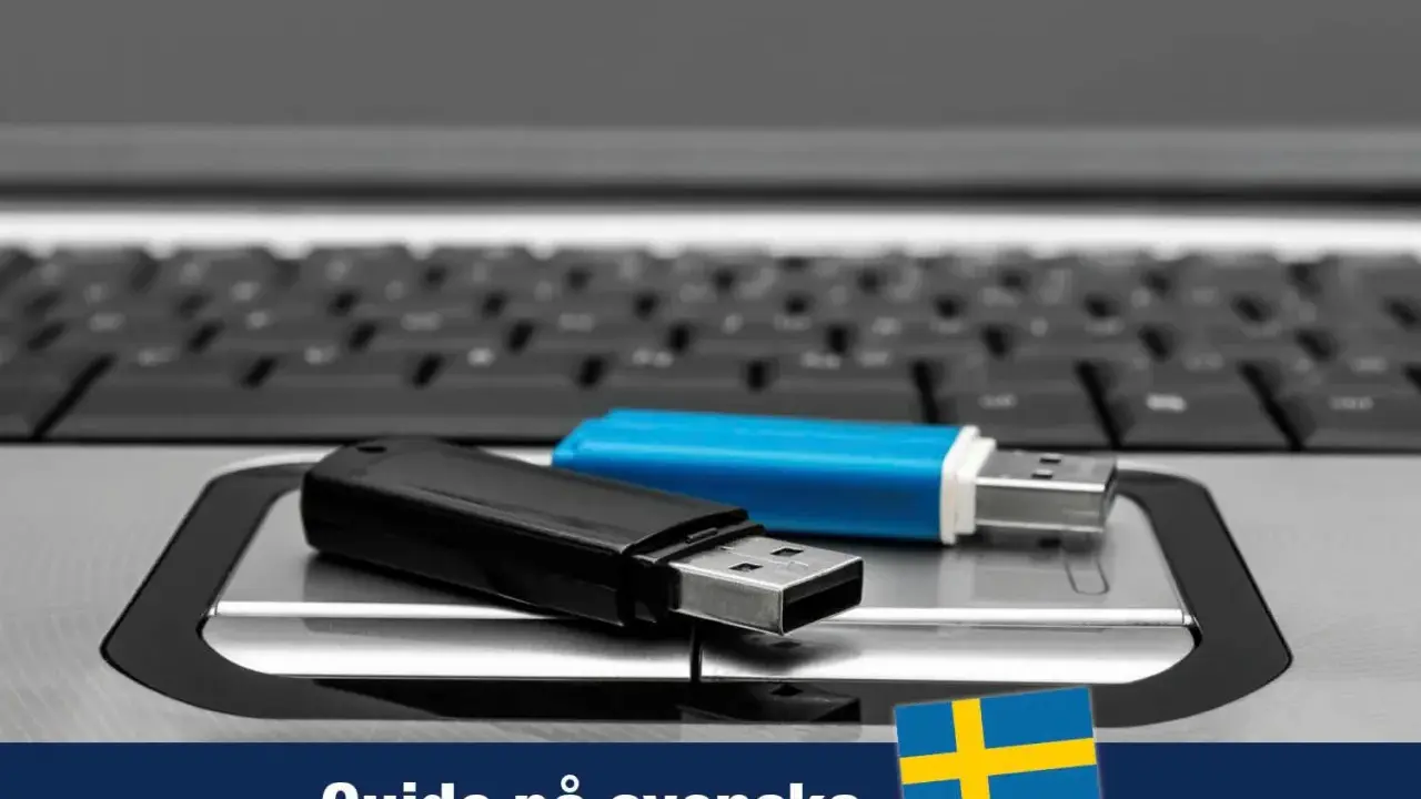 Två USB-minnen, ett svart och ett blått, ligger på ett tangentbord. En guide för Windows 11 USB på svenska.