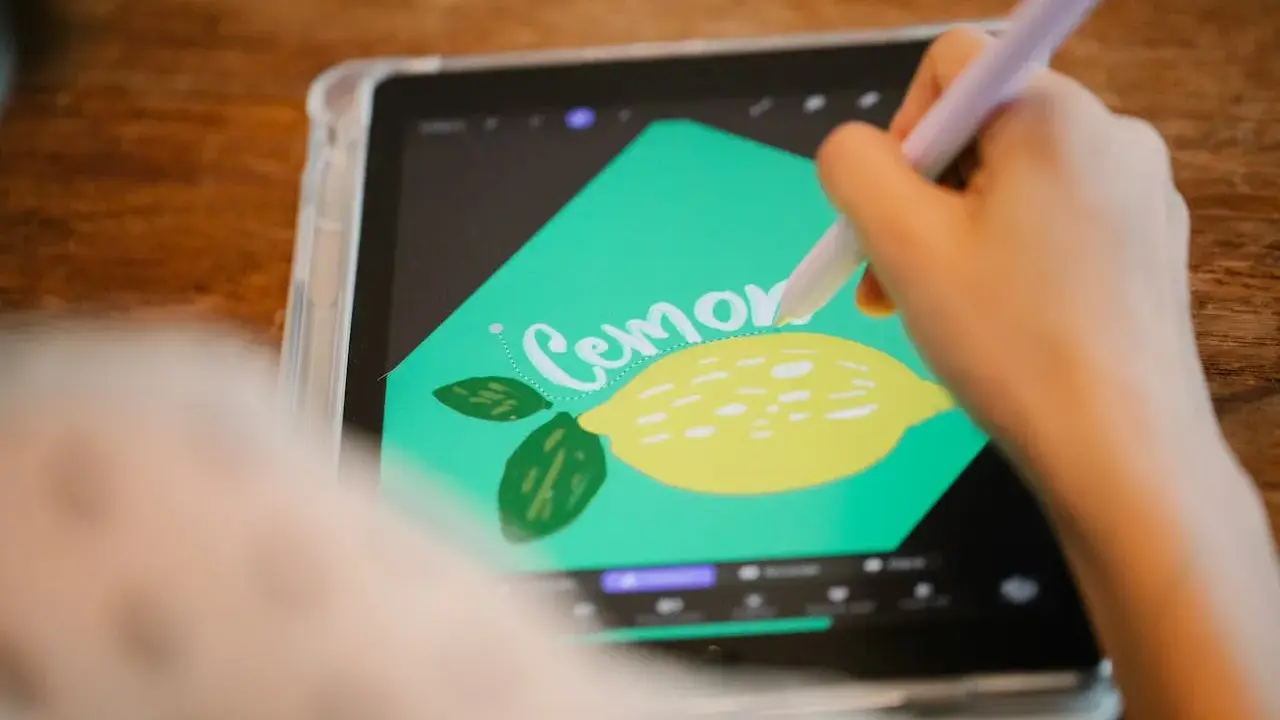 En person använder en penna för att rita en citron och texten "Cemone" i Procreate svenska på en surfplatta.