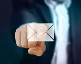 Pekande finger med ett e-post-ikon över. Dags att byta mailadress för en ny start.