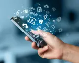 En hand håller en smartphone med en virvel av ikoner som representerar roliga appar och digitala tjänster.