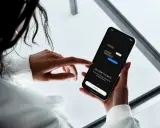 En person håller en mobiltelefon där det står "WELCOME TO CHATS". Appen hjälper dig att skapa grupp sms och hålla dina meddelanden organiserade.