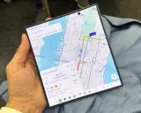 En person håller en vikbar telefon med en karta över New York City. En rutt för kollektivtrafik visas, med en restid på 35 minuter. En perfekt **galaxy unpacked** för att navigera i staden.