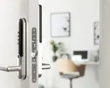 Close-up of a Yale Doorman L3 smart lock on a white door, showing the keypad and handle.