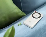 Vit ZTE U30 Air 5G portabel Wi-Fi-hotspot ligger på en blå soffa, bredvid en grön kudde.