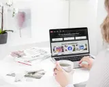 En person använder ett **publiceringsverktyg för sociala medier** på en laptop. På skärmen syns ikoner för Instagram, Facebook och LinkedIn.