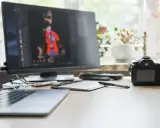 Arbetsplats med laptop, skärm som visar bildredigering, kamera och ritplatta.jpg
