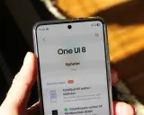 En hand håller en telefon som visar "One UI 8 Nyheter" med tips om funktioner.