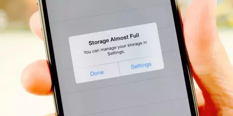 iPhone-lagringsutrymme fullt. En varning visas på skärmen: "Lagring nästan full. Du kan hantera din lagring i Inställningar.