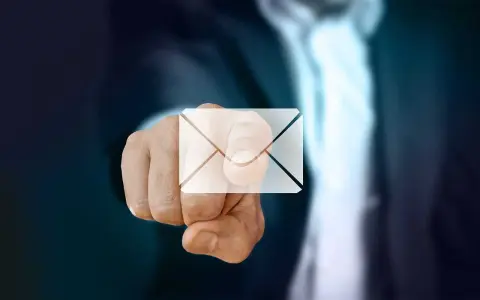 Pekande finger med ett e-post-ikon över. Dags att byta mailadress för en ny start.