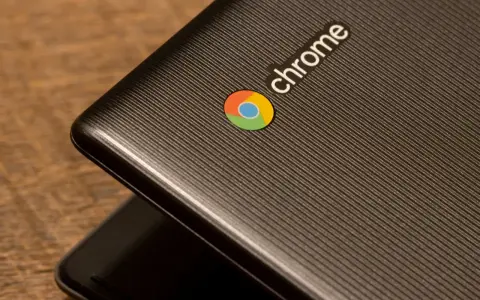 En närbild av en mörk laptop med Chrome-logotypen. Denna enhet kör ChromeOS Flex, vilket ger en smidig upplevelse.