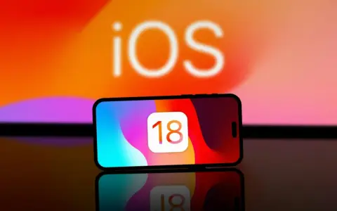 iPhone med iOS 18-ikonen. Kanske dags att byta namn på iPhone för att spegla den nya versionen?