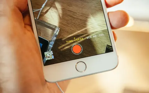 En hand håller en iPhone med inspelningsläget TIME-LAPSE aktivt. En röd inspelningsknapp syns på skärmen.