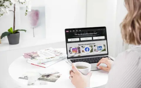 En person använder ett **publiceringsverktyg för sociala medier** på en laptop. På skärmen syns ikoner för Instagram, Facebook och LinkedIn.