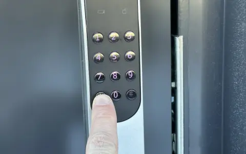 En finger trycker på nollan på en Yale Doorman V2N med wifi.