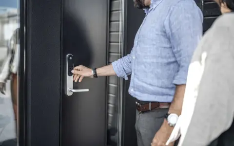 Man trycker på siffror för att installera Yale Doorman. Enkel och modern dörrlåsning.