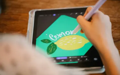 En person använder en penna för att rita en citron och texten "Cemone" i Procreate svenska på en surfplatta.