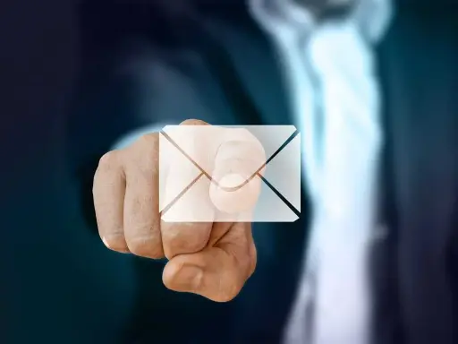Pekande finger med ett e-post-ikon över. Dags att byta mailadress för en ny start.