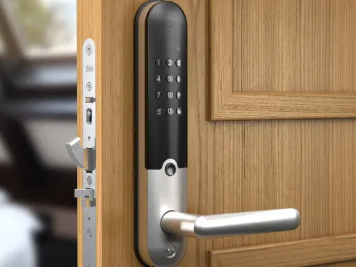 En modern Yale doorman med digitalt tangentbord och handtag på en träport.