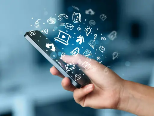 En hand håller en smartphone med en virvel av ikoner som representerar roliga appar och digitala tjänster.