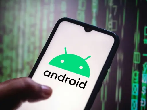 En hand håller en smartphone med Android-logotypen. Bakgrunden visar gröna siffror och symboler, som en kod.