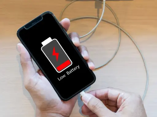 En person försöker ladda sin mobil, men den laddar inte. Batteriikonen visar låg nivå.
