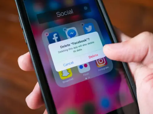 En finger trycker på "Delete" på en iPhone. En ruta frågar om man vill radera Facebook och dess data. Detta är inte hur man uppdaterar en app.
