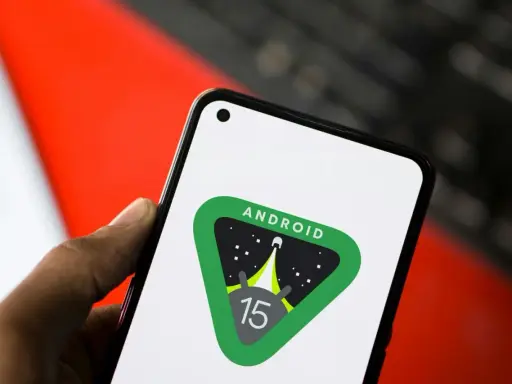 En hand håller en telefon med Android 15-logotypen, en raket som skjuter upp mot stjärnorna.