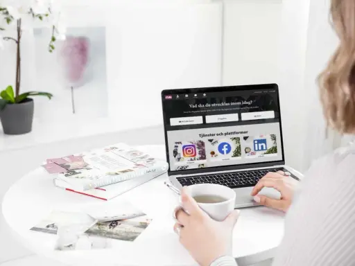 En person använder ett **publiceringsverktyg för sociala medier** på en laptop. På skärmen syns ikoner för Instagram, Facebook och LinkedIn.