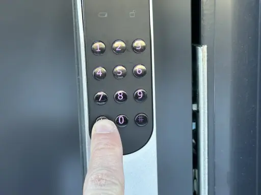 En finger trycker på nollan på en Yale Doorman V2N med wifi.
