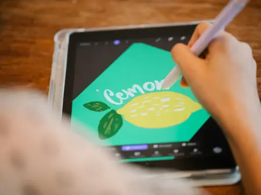 En person använder en penna för att rita en citron och texten "Cemone" i Procreate svenska på en surfplatta.
