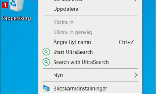 Här är en skärmdump av en dator där man kan se en ikon för "Papperskorg" och en meny. Var hittar jag papperskorgen? Den är markerad med siffran 1.