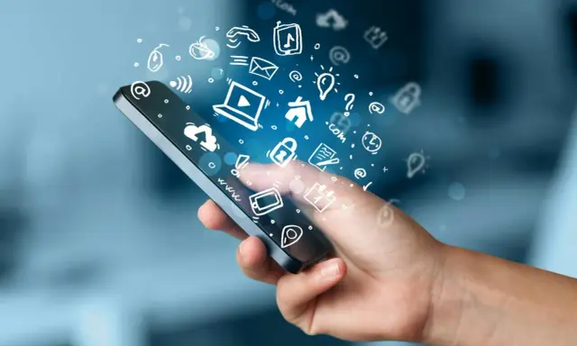 En hand håller en smartphone med en virvel av ikoner som representerar roliga appar och digitala tjänster.