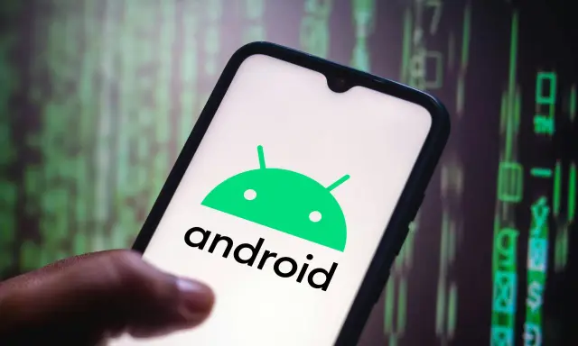 En hand håller en smartphone med Android-logotypen. Bakgrunden visar gröna siffror och symboler, som en kod.