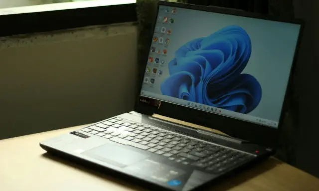 En bärbar dator med Windows 11-skärm och dess ikoniska blåa bakgrundsbild. Denna dator uppfyller troligen alla **windows 11 krav**.