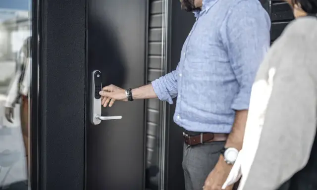 Man trycker på siffror för att installera Yale Doorman. Enkel och modern dörrlåsning.