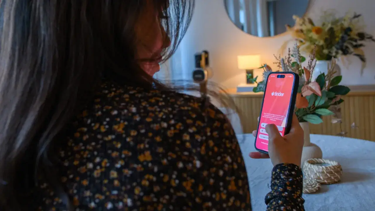 Kvinna använder Tinder, en av många dejting appar, på sin mobiltelefon.