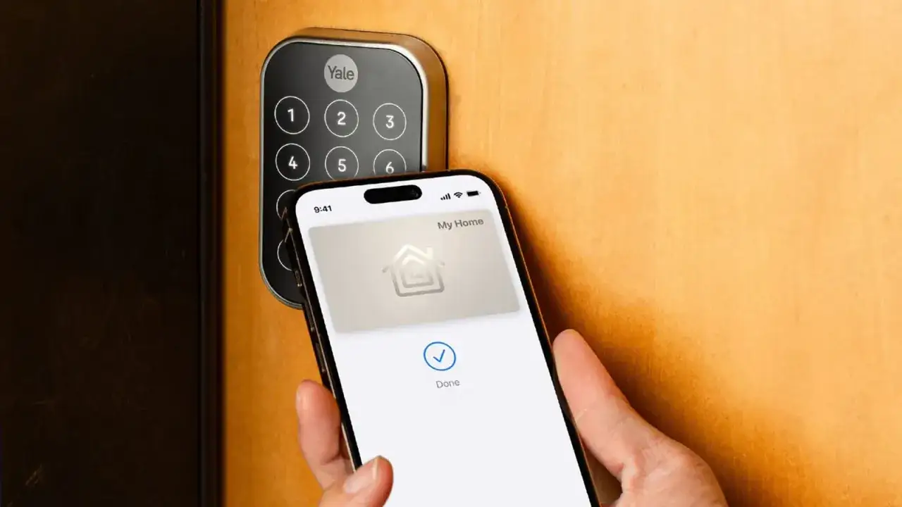 En hand h&aring;ller upp en iPhone med Apple HomeKit-appen som visar 