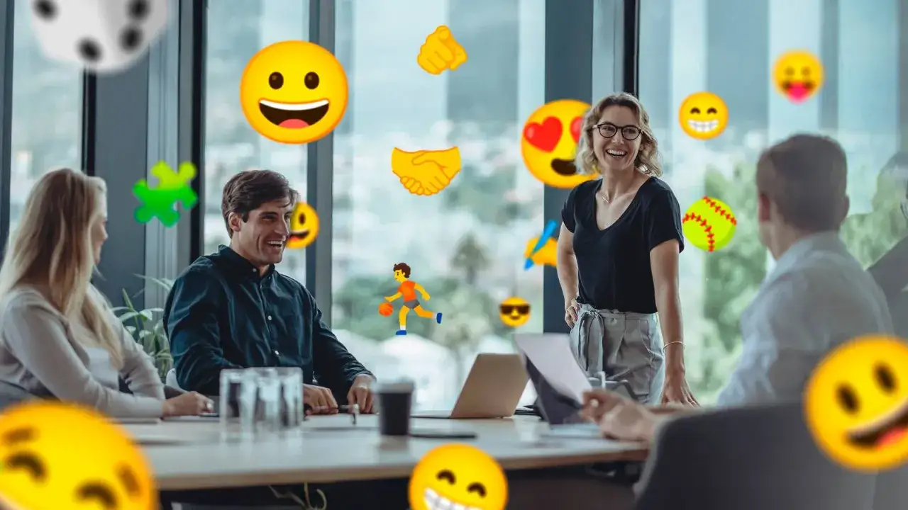 Glada kollegor i mötesrum med emojis som symboliserar samarbete och positiv energi. Förståelse för emoji betydelse i arbetslivet.