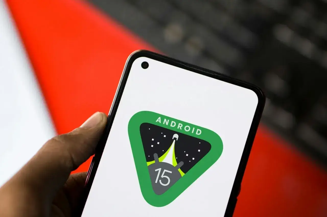 En hand h&aring;ller en telefon med Android 15-logotypen, en raket som skjuter upp mot stj&auml;rnorna.