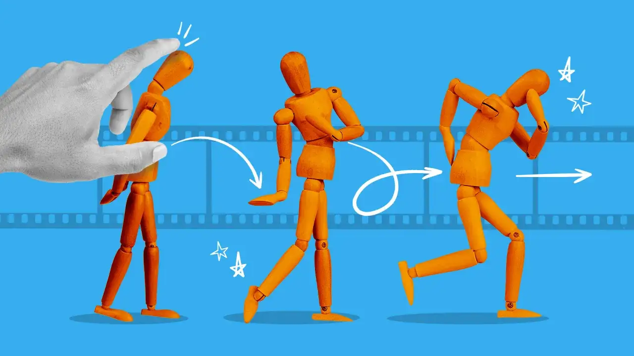 En hand flyttar en tr&auml;figur i olika positioner, som en del av en stop motion film.